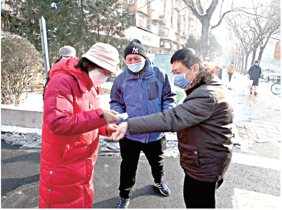 3月27日，西城区人力资源和社会保障局党员干部为社区群众测量体温.jpg